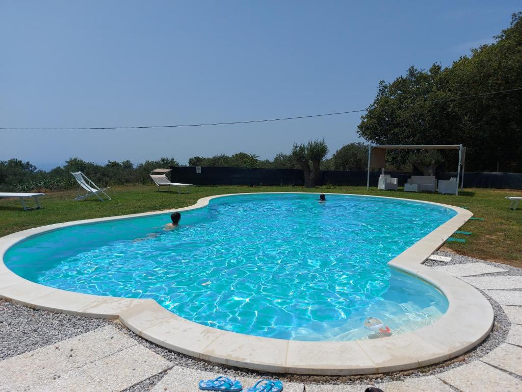 a large swimming pool with blue water in a yard at Villa Mimosa Tropea in Ricadi