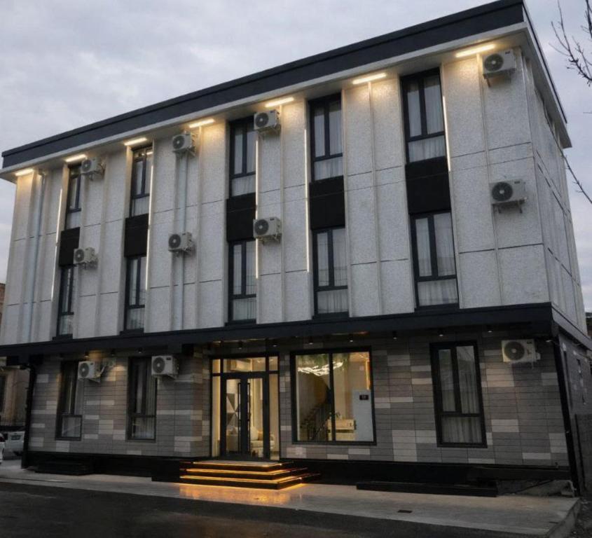 a large white building with windows on a street at NINETY boutique hotel in Yakkasaray
