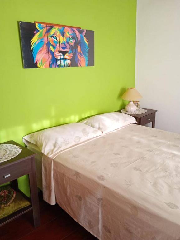 a bedroom with a bed and a painting of a lion at La esquina amarilla in San Clemente del Tuyú