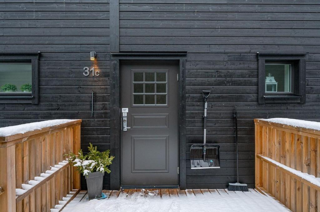 a front door of a house with snow on the ground at Kungsberget Ski apartment 31C in Järbo