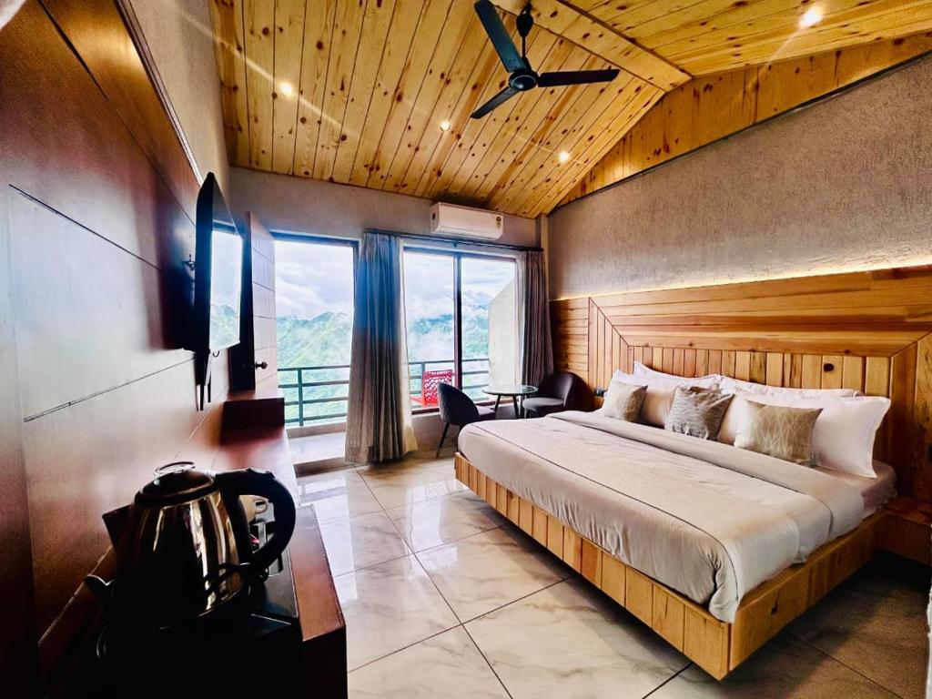 a bedroom with a large bed with a ceiling fan at Living On The Edge A Luxury Stay in Mussoorie in Mussoorie