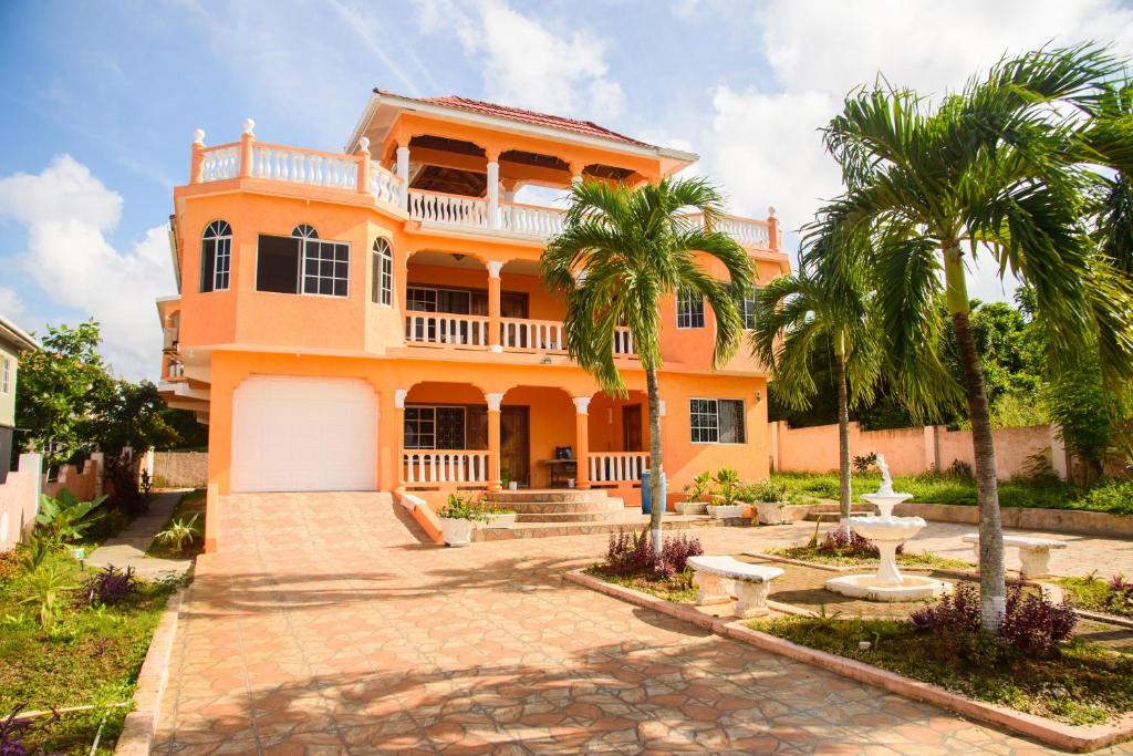 an orange house with palm trees and a fountain at Destiny Seaside in Content