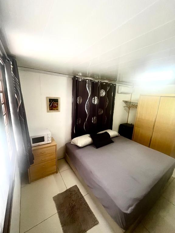 a bedroom with a large bed and a television at Ritualodge in Bora Bora
