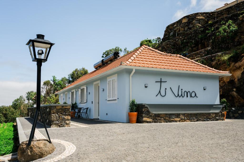 a white building with a sign that reads wine at Casa Ti'Vina in Caniço