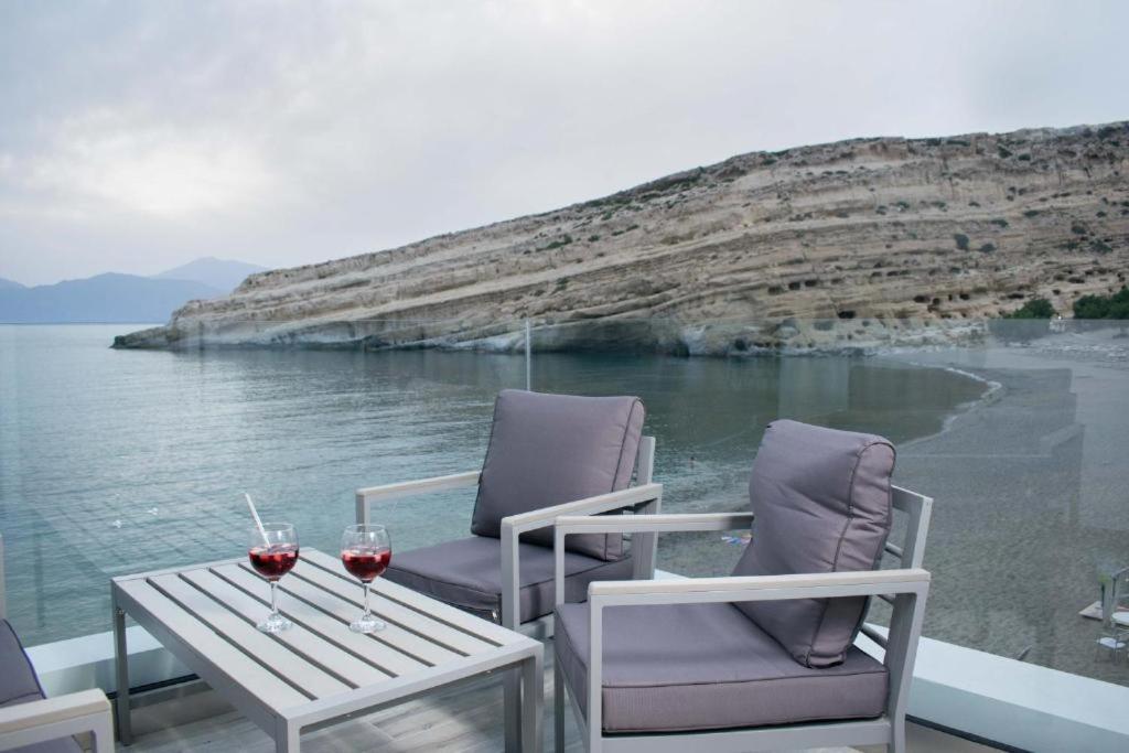 two glasses of wine sitting on a table on a boat at Thalassoresort UPSTAIRS in Matala