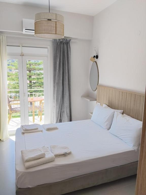 a bedroom with a large white bed with towels on it at Theoni Garden in Parga