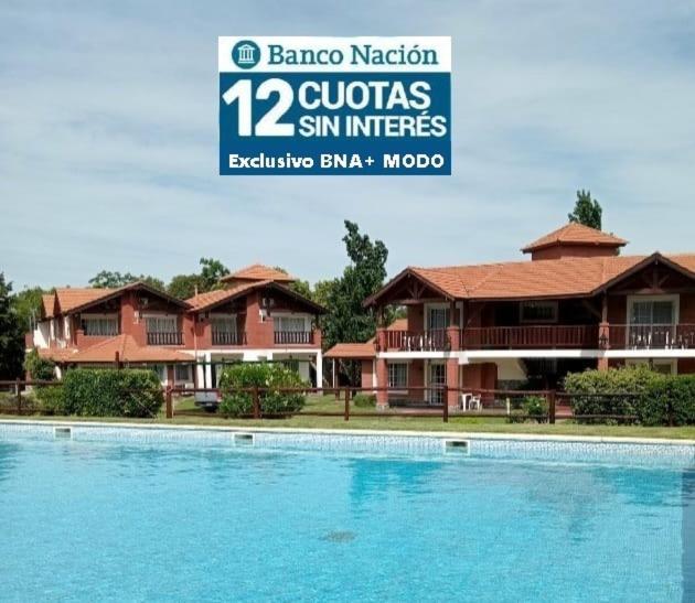 a large swimming pool in front of a house at Posada Los Alamos in Merlo