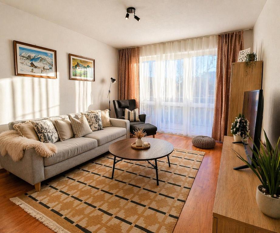a living room with a couch and a table at Apartmán v centre Donovaly s garážou in Donovaly