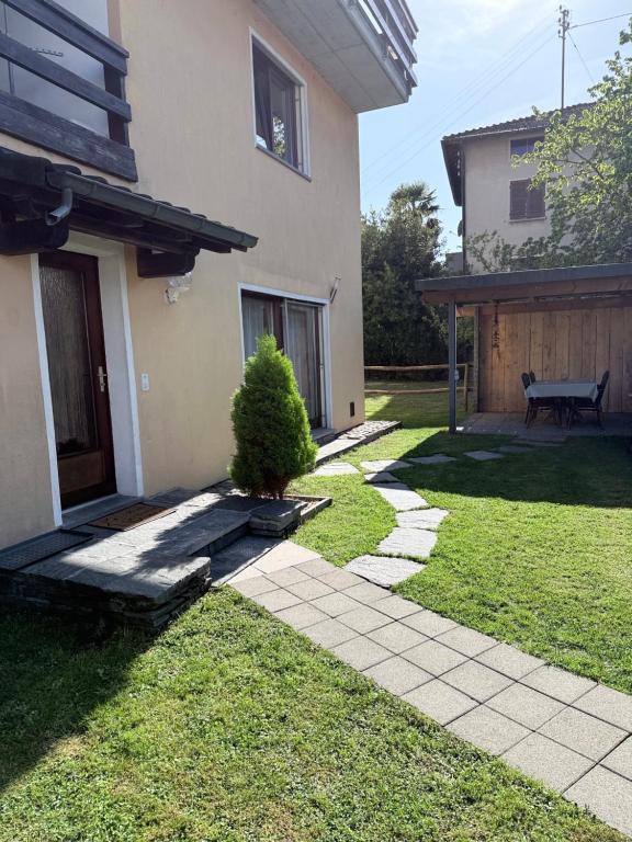 a yard with a house and a bench next to it at Angolo del Tramonto in Gambarogno