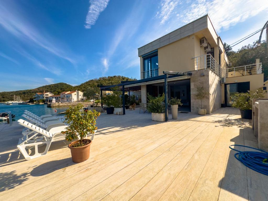 a house with a wooden deck next to the water at Villa Tajna in Tivat