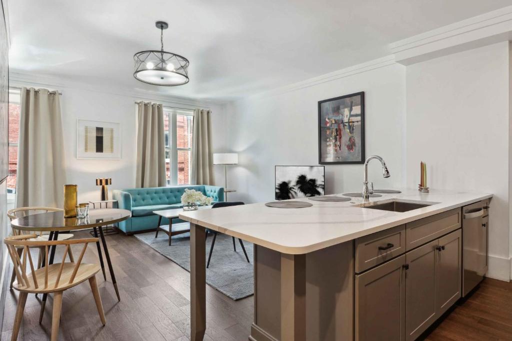 a kitchen and living room with a sink and a table at Contemporary Condo Downtown Savannah in Savannah