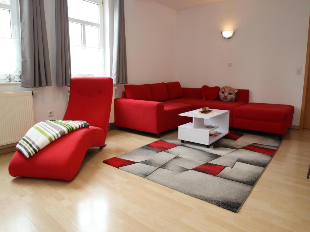a living room with a red couch and a rug at Ferienwohnung in Elbingerode by Belvilla in Elbingerode