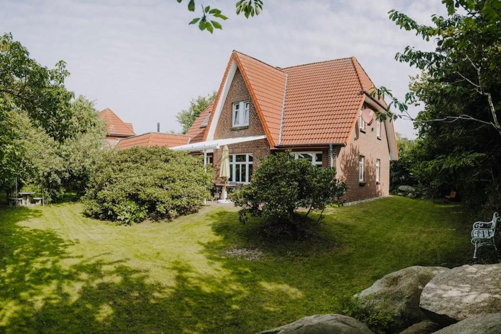 a house with a large yard in front of it at Friesenpark 8 in Wurster Nordseeküste