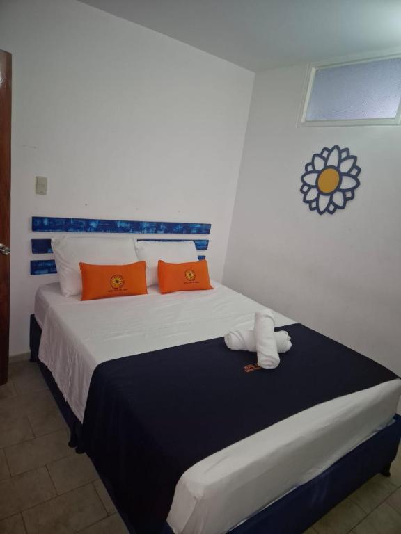 a bedroom with a large bed with orange pillows at Hotel Girasol in Santa Rosa de Cabal