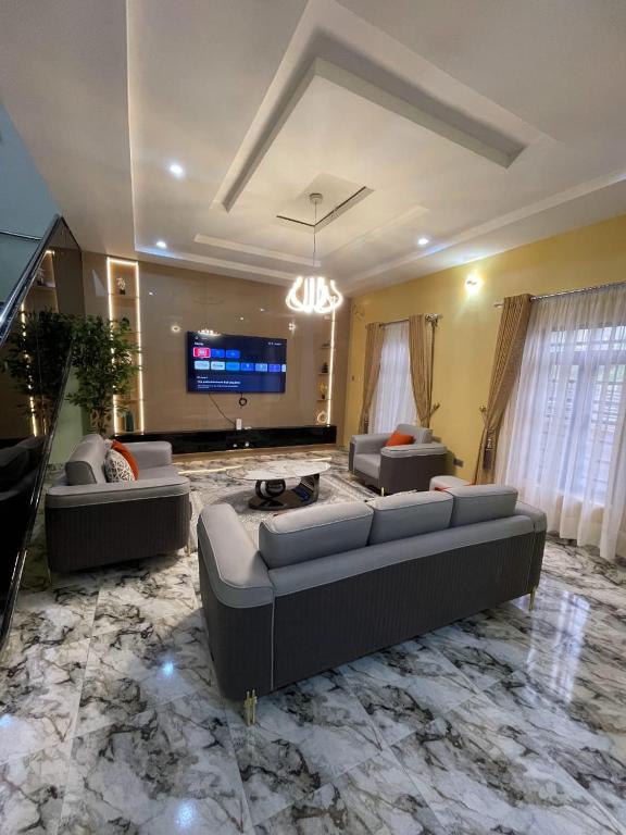 a large living room with two couches and a tv at Goshen in Iju Junction