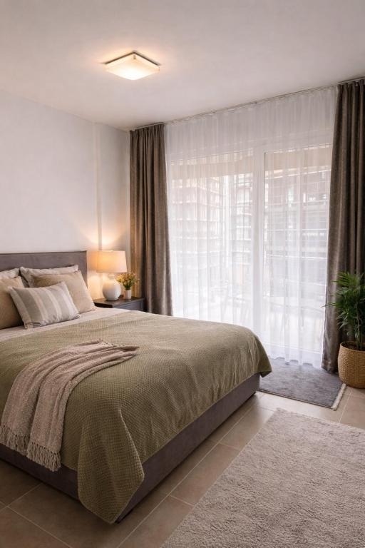 a bedroom with a large bed and a large window at Holiday apartaments Gaca in Lezhë