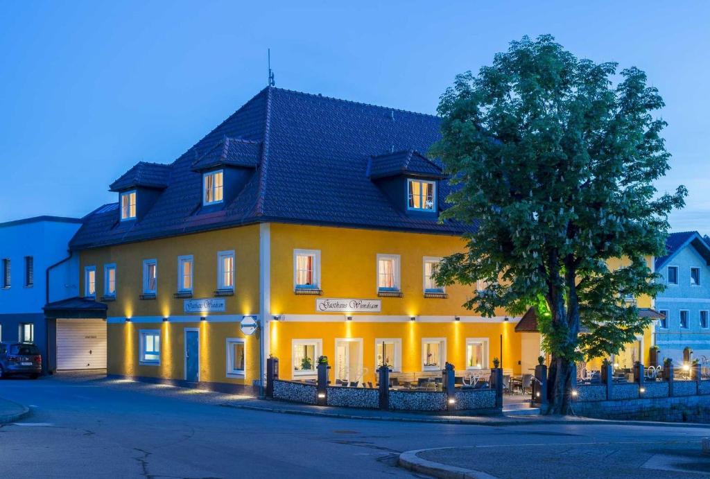 a large yellow house with a black roof at Gasthaus Wundsam in Neustift im Mühlkreis