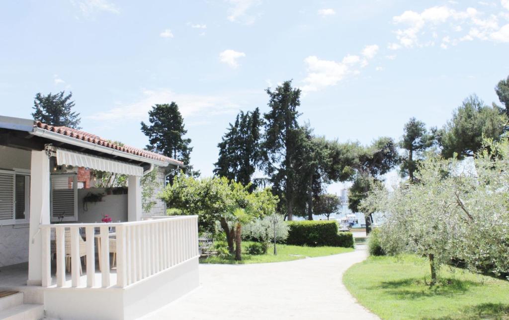 a house with a white fence and trees at House PUNTA II in Umag