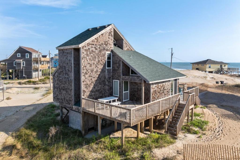 a small house on the beach with the ocean at 7026 - Southwind in Rodanthe