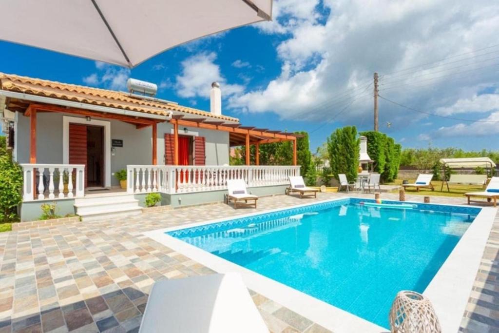 a villa with a swimming pool and a house at Pothos Villas in Zakynthos