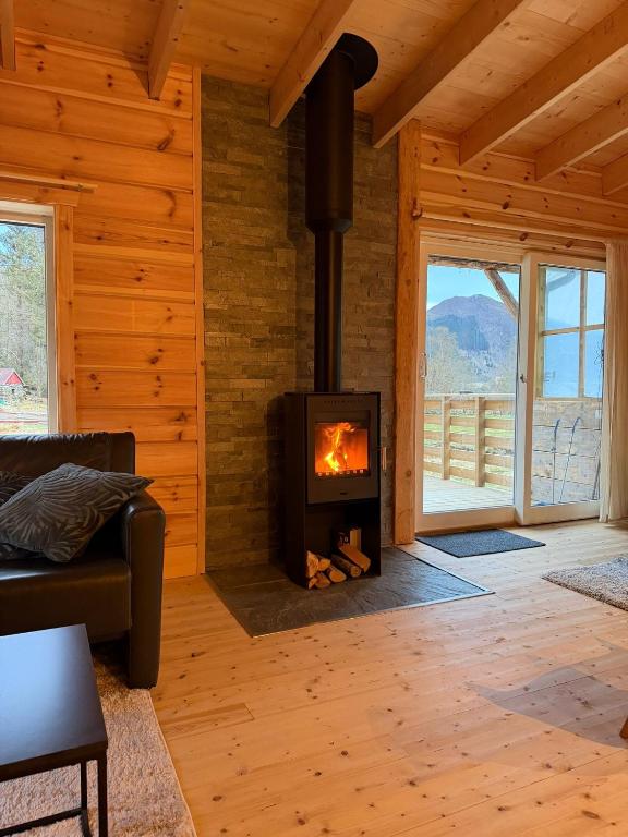 a living room with a fireplace in a log cabin at Deer Cottage in Sylte