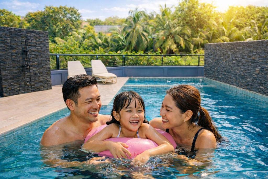 a man and a woman and a girl in a swimming pool at Kathu V pool villa 170 in Kathu