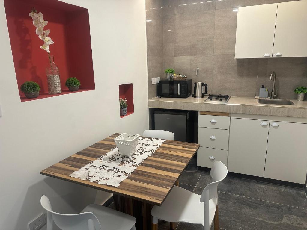 a kitchen with a wooden table and white cabinets at Aqui es 8!! in Banfield
