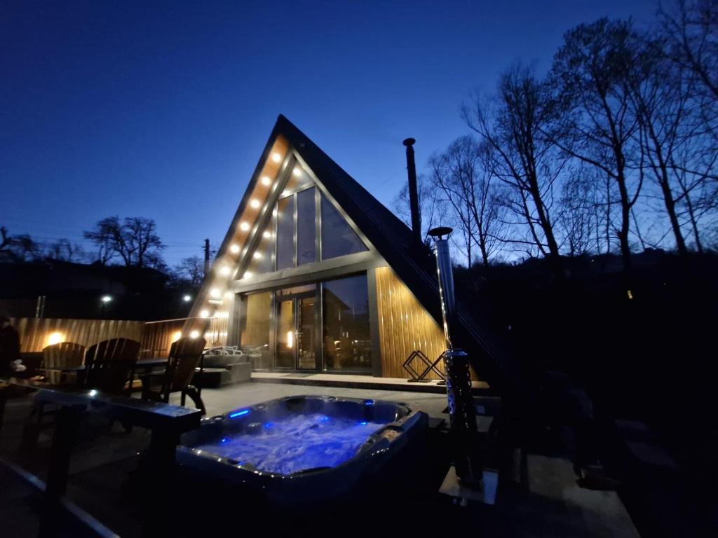 ein Haus mit einem Whirlpool im Hof bei Nacht in der Unterkunft AVA Chalet in Comarnic
