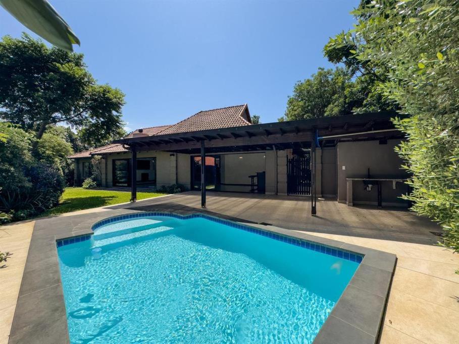 a swimming pool in front of a house at The Pearl Ballito in Ballito
