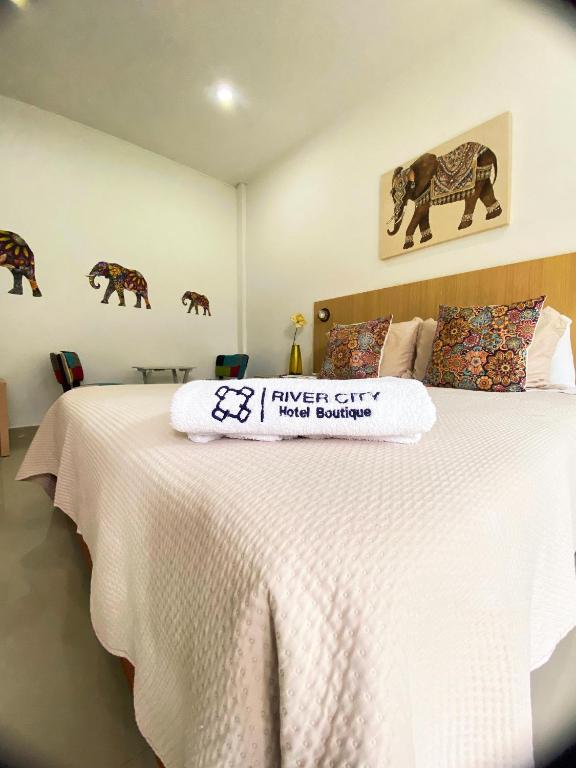 a bedroom with a bed with a sign on it at Hotel River City in Montería