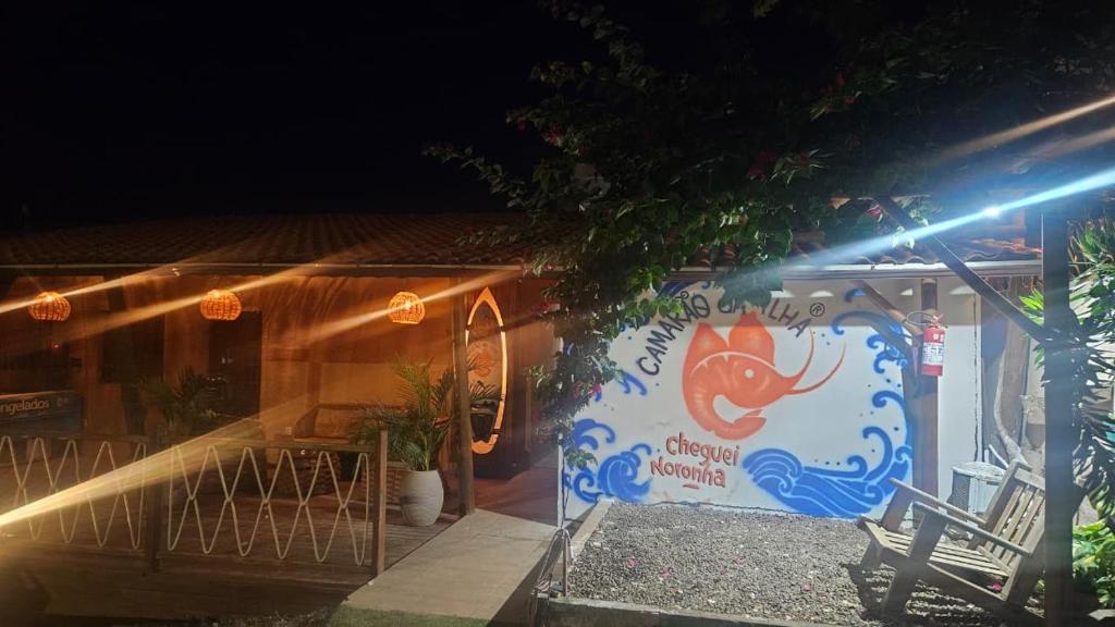 a sign on the side of a building at night at Hospedaria Camarão da ilha in Fernando de Noronha
