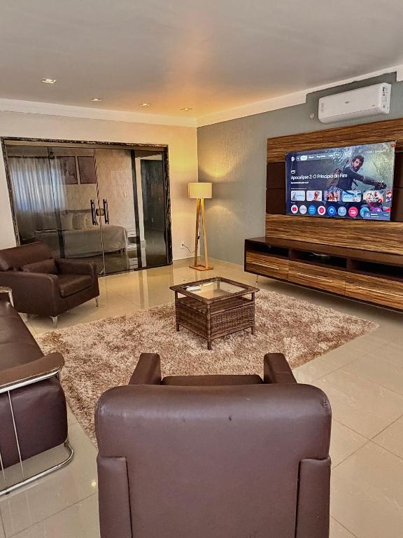a living room with a couch and a tv at CASA AMPLA e MODERNA com Suíte in Porto Velho