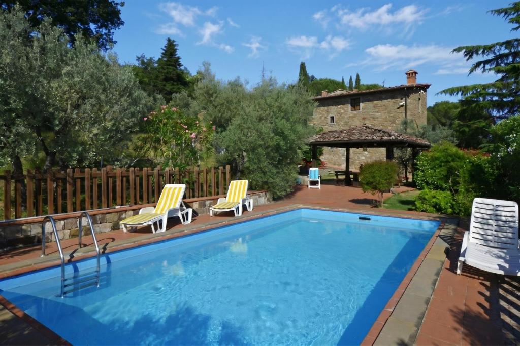a swimming pool with chairs and a house at Casa Citille - Happy Rentals in Greve in Chianti