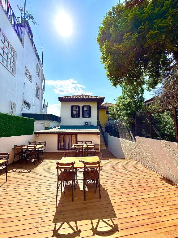 a patio with tables and chairs on a wooden deck at Marina Hostel Pansiyon in Antalya