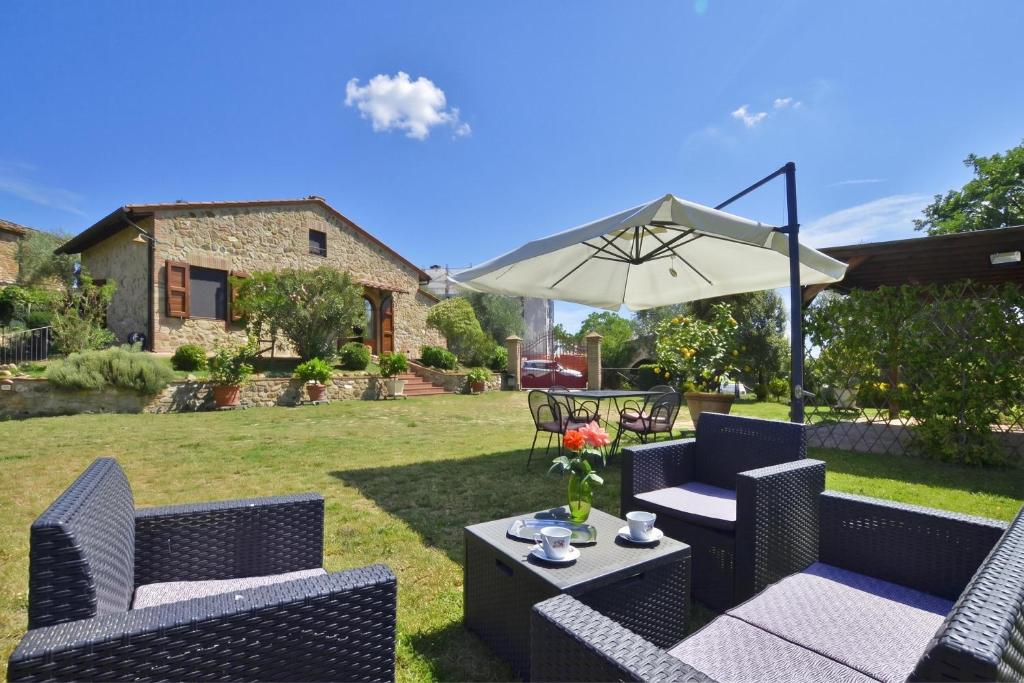 a patio with a table and chairs and an umbrella at Da Maria - Happy Rentals in Murlo