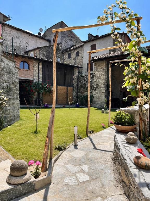 a garden with a wooden arch in a yard at B&B Il Podestà in Garbagna