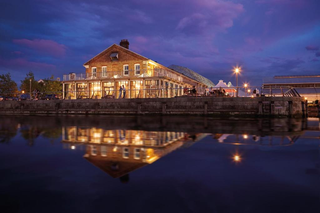 a building with lights on the water at night at The Ship & Trades in Chatham