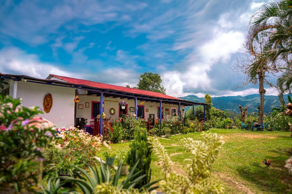 a house with a red roof and a yard at Finca Cafetera Los Ángeles in Líbano