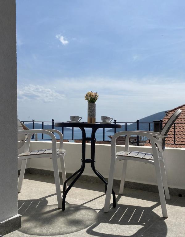 a table and two chairs on a balcony with a view at Bay Horizon View in Igalo