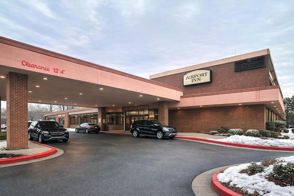 a car dealership with two cars parked in a parking lot at Airport Inn Memphis Near Graceland By Hotel O in Memphis