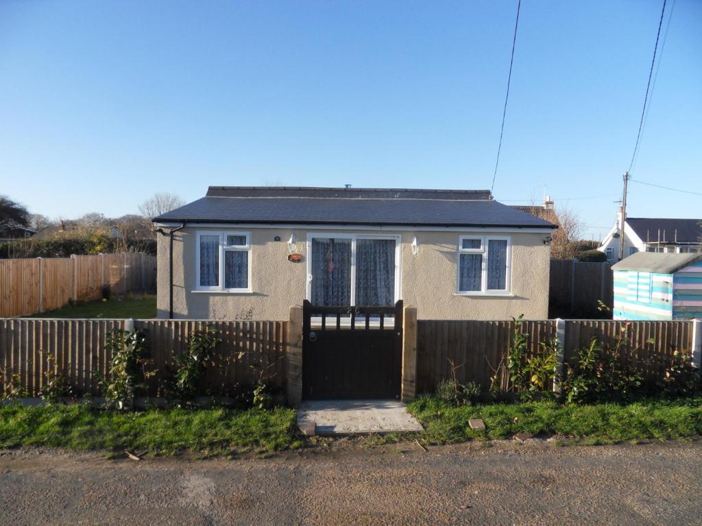 a small house with a fence and a gate at Dawn in Hemsby
