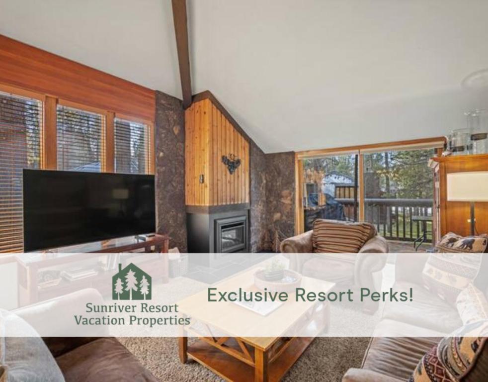 a living room with a tv and a table at 61 Wildflower in Sunriver