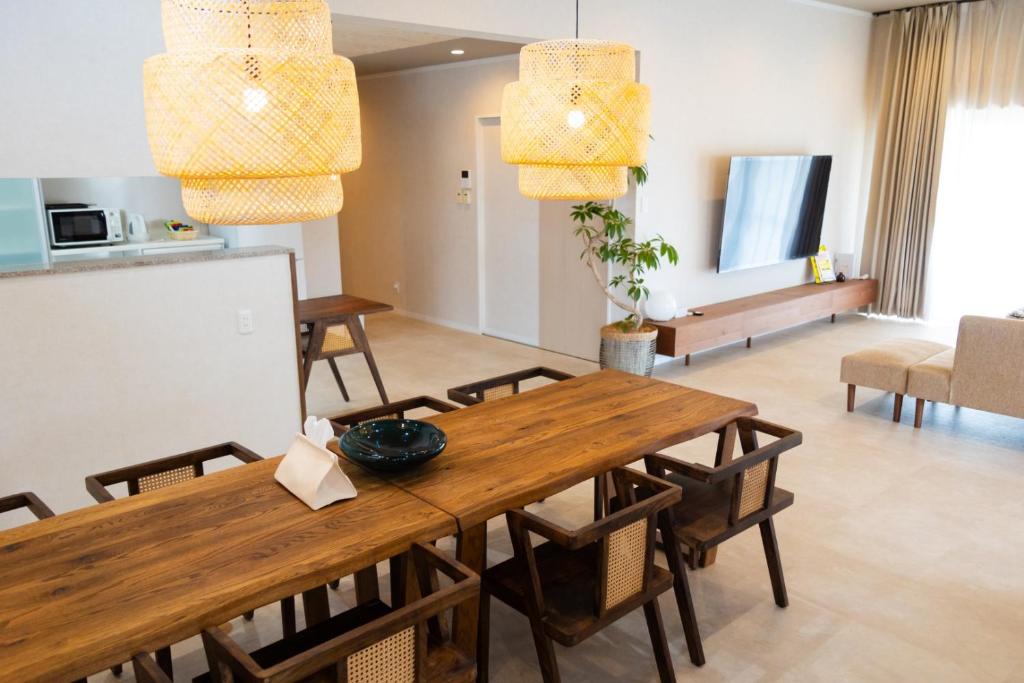 a kitchen and dining room with a table and chairs at YMA House in Nago
