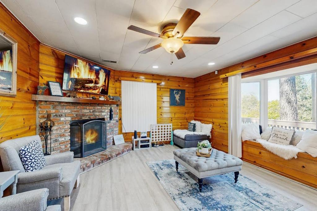 ein Wohnzimmer mit Kamin und Deckenventilator in der Unterkunft Crestline Charm in Crestline