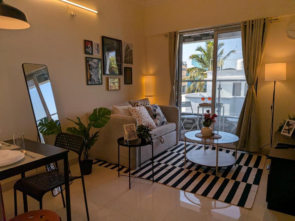 a living room with a couch and a table at Nova Residences Viman Studios in Pune