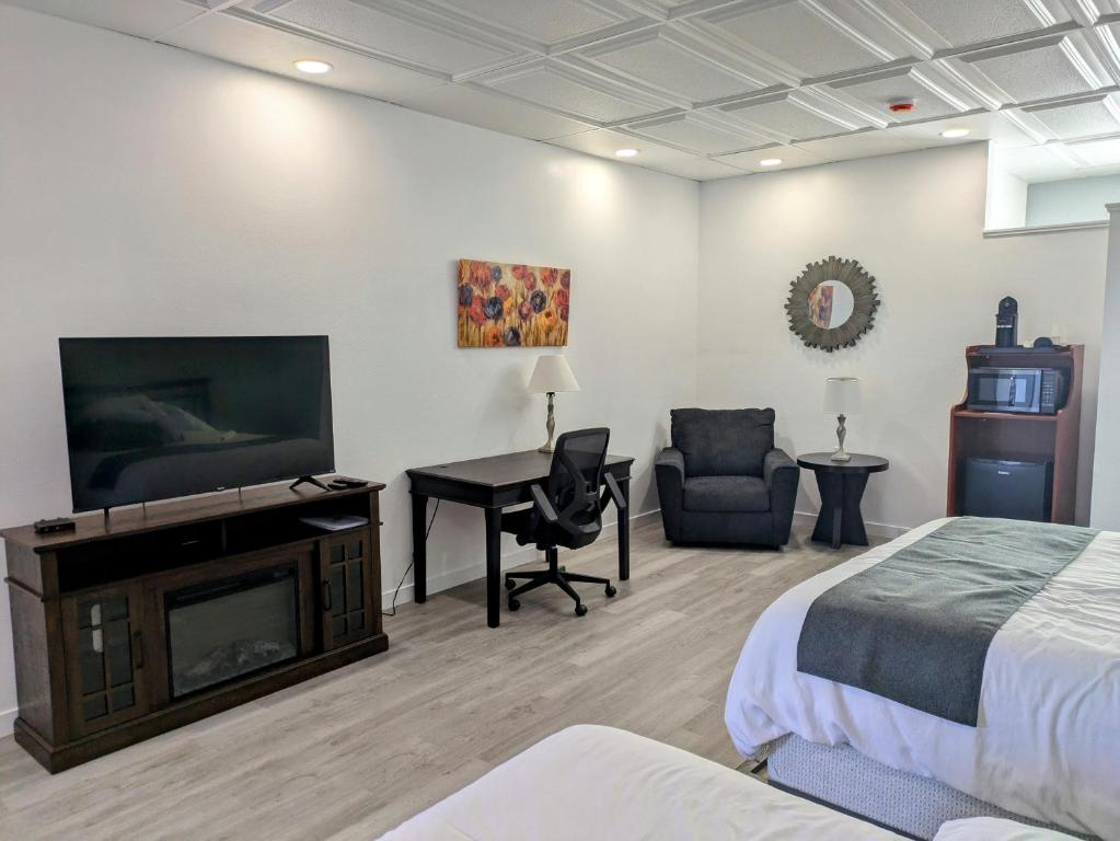 a bedroom with a bed and a television and a desk at Chelan Valley Inn in Manson