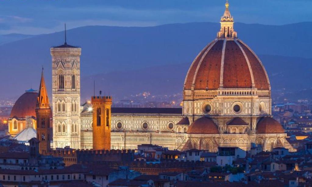 a large building with two domes in a city at Casa Bertini in Florence