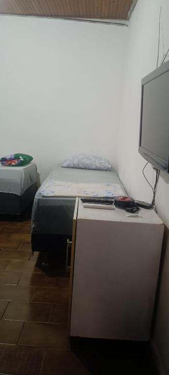 a bedroom with a bed and a computer on a desk at Pousada Popular in Barreiras