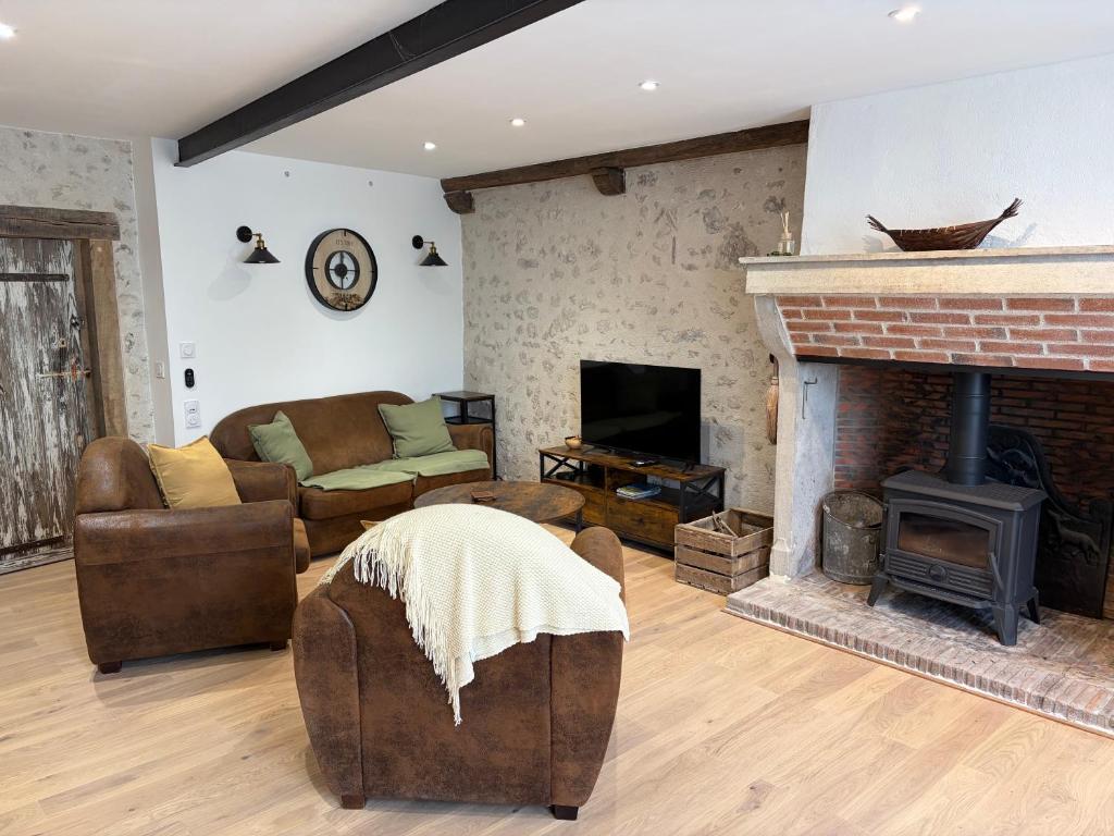a living room with a couch and a fireplace at Gîte de La Petite Mauve in Baule
