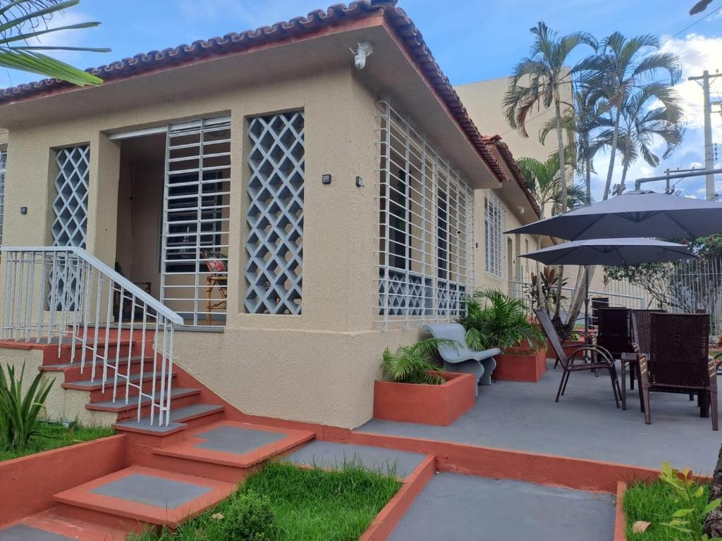 a house with a patio with a table and an umbrella at Vintagyn Hostel in Goiânia